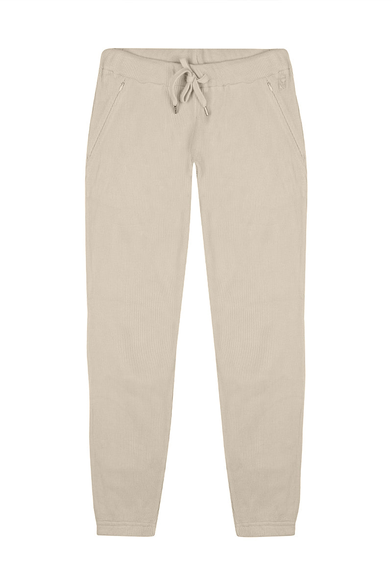 Beige waffle sweatpants by Bassigue, casual pants made from soft, textured fabric with an elastic waistband and relaxed fit.