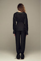 Black Scylla Pants by IKINITA, shown on a model, featuring a stylish, tailored fit with clean lines and comfortable fabric.