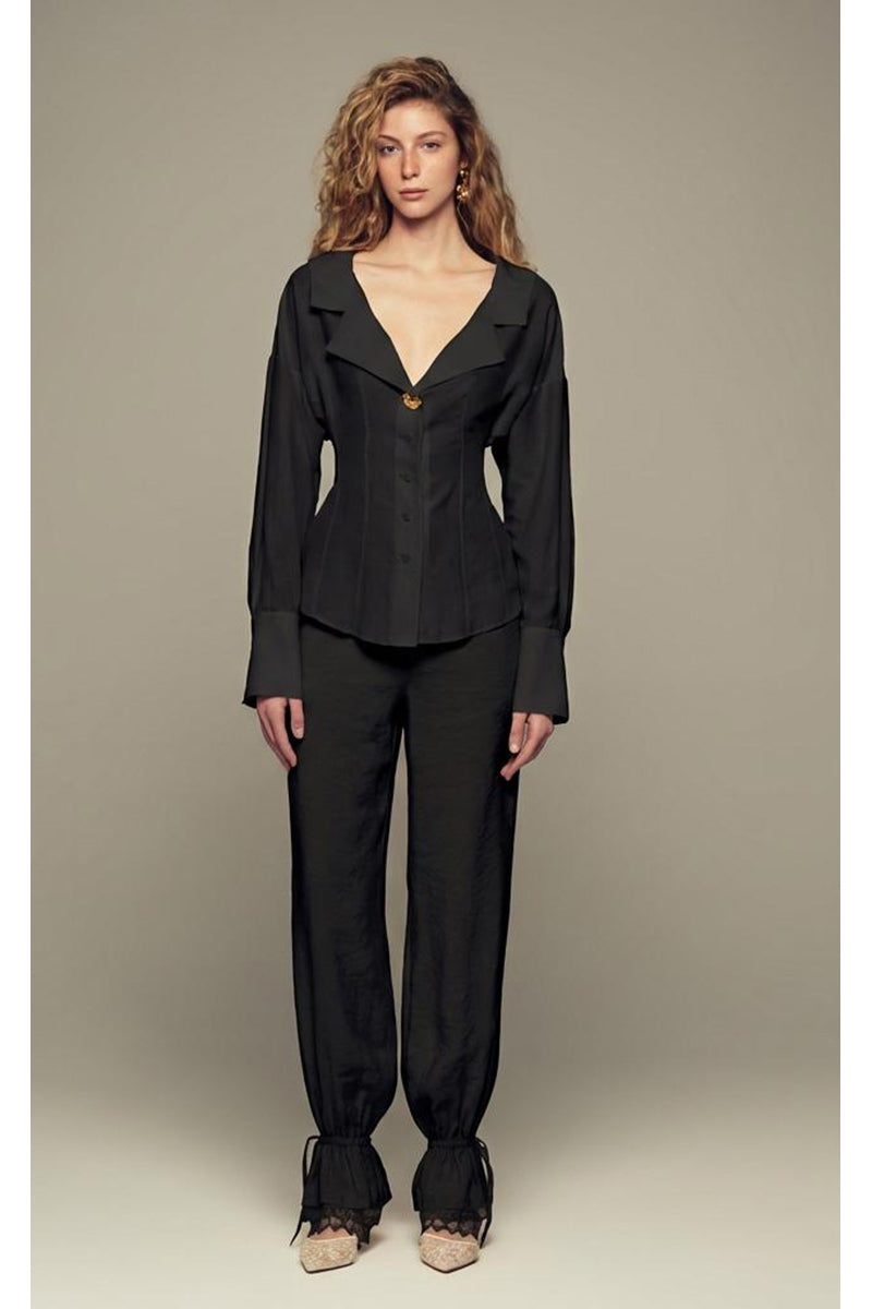 Black Scylla pants by IKINITA shown in the image, featuring a sleek, tailored design perfect for stylish casual or semi-formal wear.