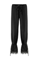 Black Scylla pants by IKINITA displayed on a model, featuring a stylish, tailored fit and sleek fabric for a modern look.