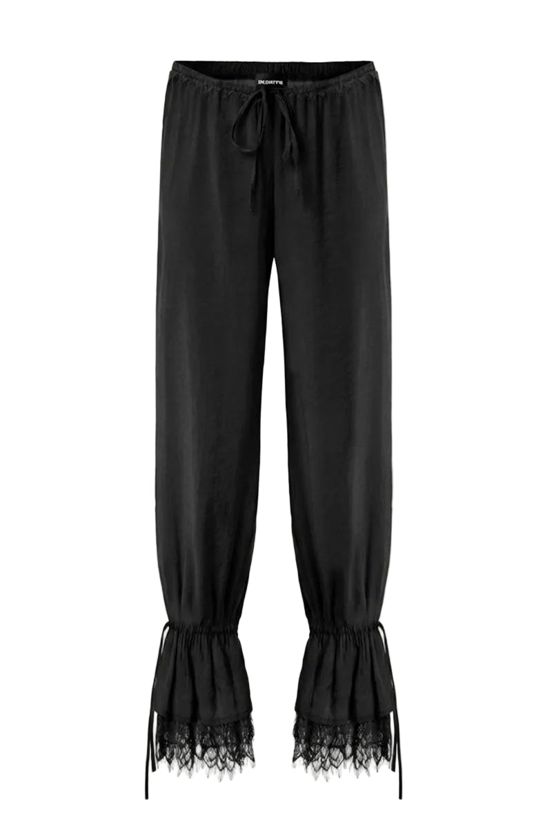 Black Scylla pants by IKINITA displayed on a model, featuring a stylish, tailored fit and sleek fabric for a modern look.