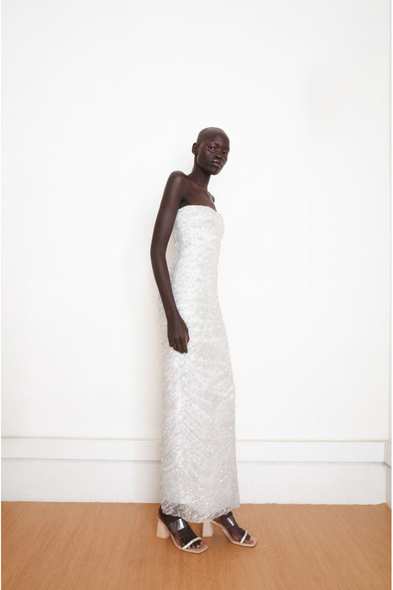 Silver YASSMIN SALEH Whispers Gown shown from the side, featuring elegant fabric and detailed design for formal occasions.