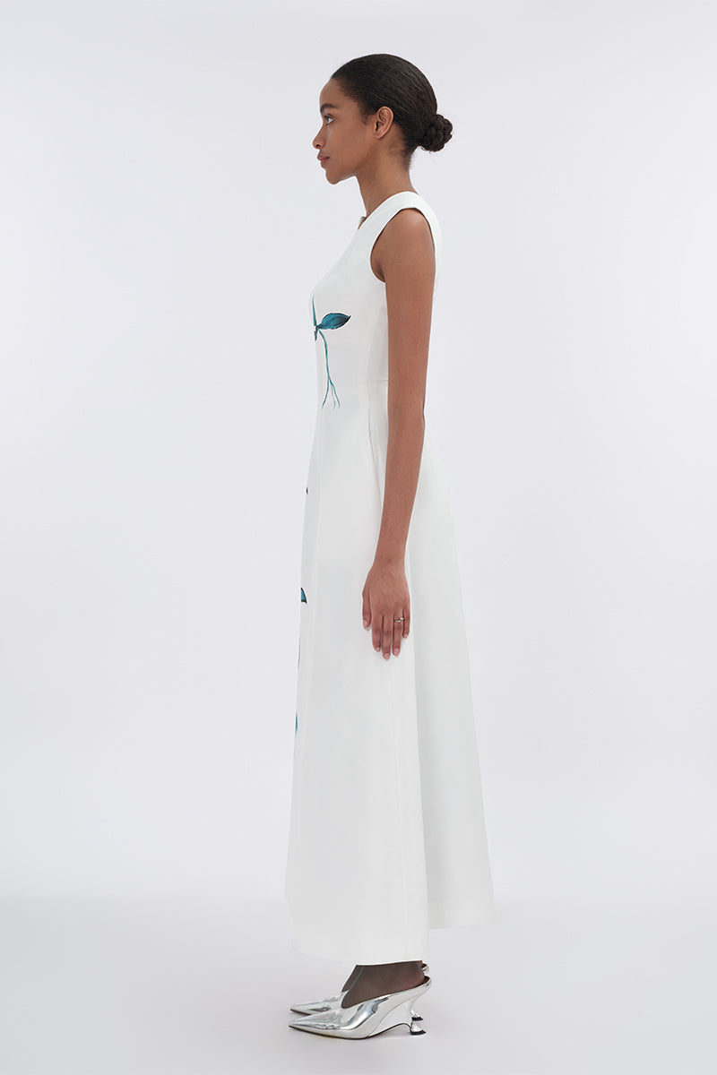 White asymmetrical flared maxi dress by Tiny Ink, flowing fabric with a unique hemline, perfect for elegant summer occasions.