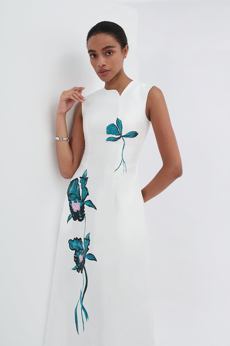 White asymmetrical flared maxi dress by Tiny Ink, flowing fabric with a stylish uneven hem and elegant silhouette.