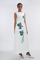 White asymmetrical flared maxi dress by Tiny Ink, featuring flowing fabric and stylish uneven hem for a chic summer look.