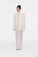 White Montsand Bailey jacket displayed on a hanger, showcasing its sleek white fabric and stylish collar design.
