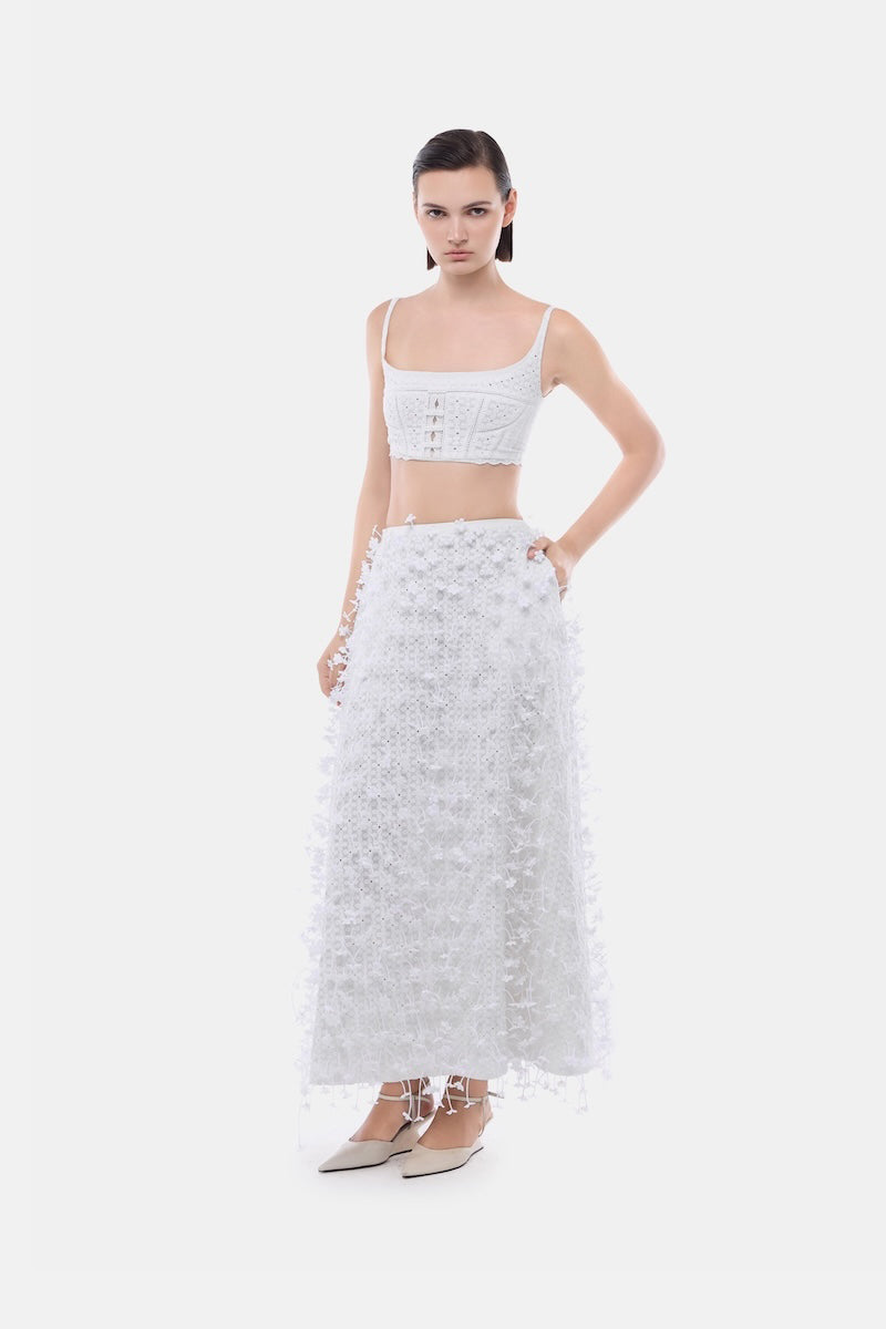 White 3D floral midi skirt by Montsand, featuring a flowy design and intricate floral embroidery, paired with a white crop top.