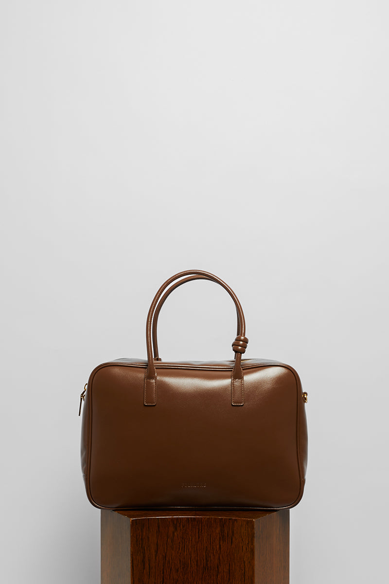 Leather work bag in mocha color with top handle from Folklore The Label, featuring a sleek, professional design.