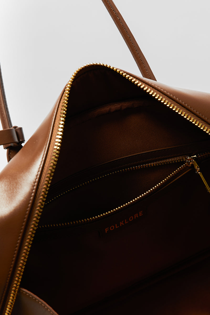 Leather work bag in mocha color with top handle, by Folklore The Label, featuring a spacious interior and elegant design.