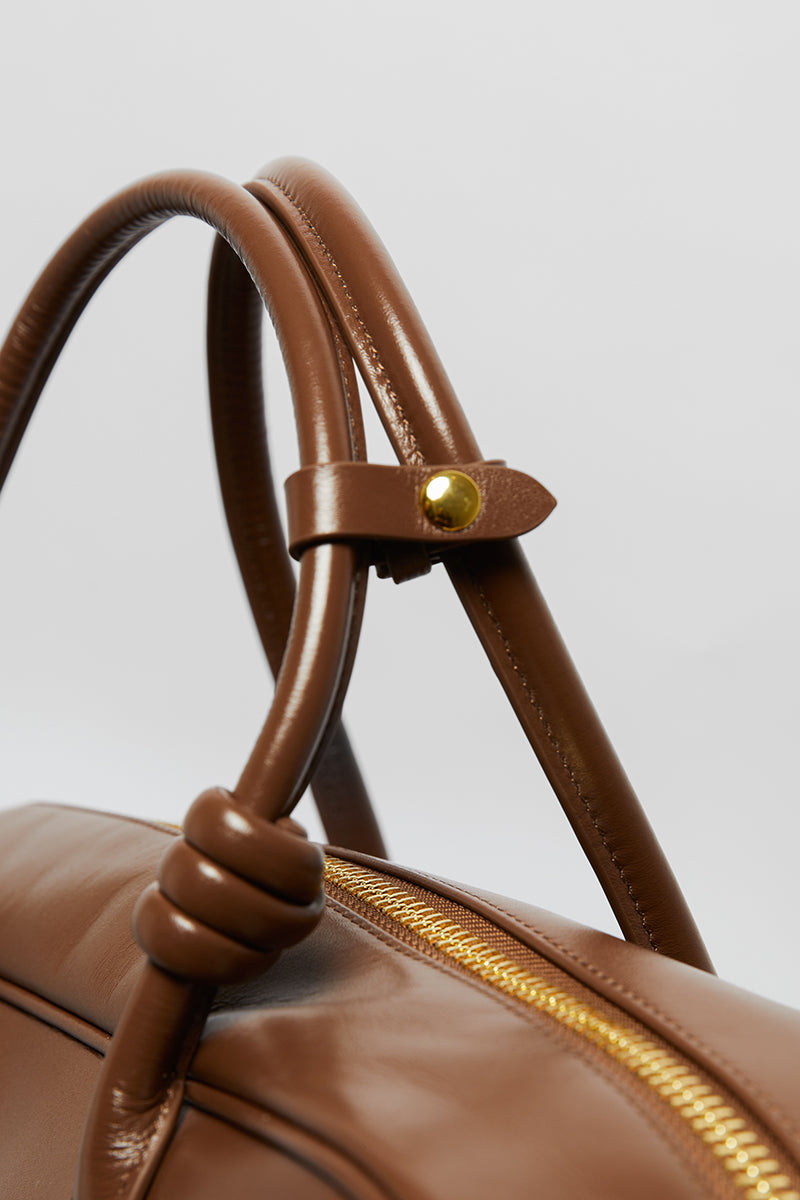 Leather work bag in mocha color with top handle, by Folklore The Label, featuring a sleek and stylish design.