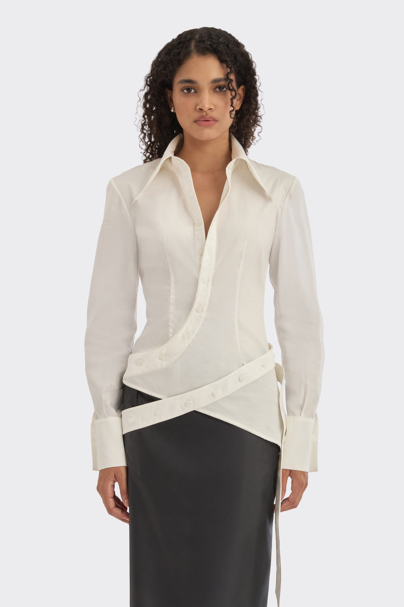 White wrap button shirt by Stolen Stores, shown on model, featuring a classic collar and long sleeves for a stylish casual look.