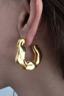 Gold wrinkled hoop earrings by Oz Objects, showcasing textured, irregular hoops with a matte finish.