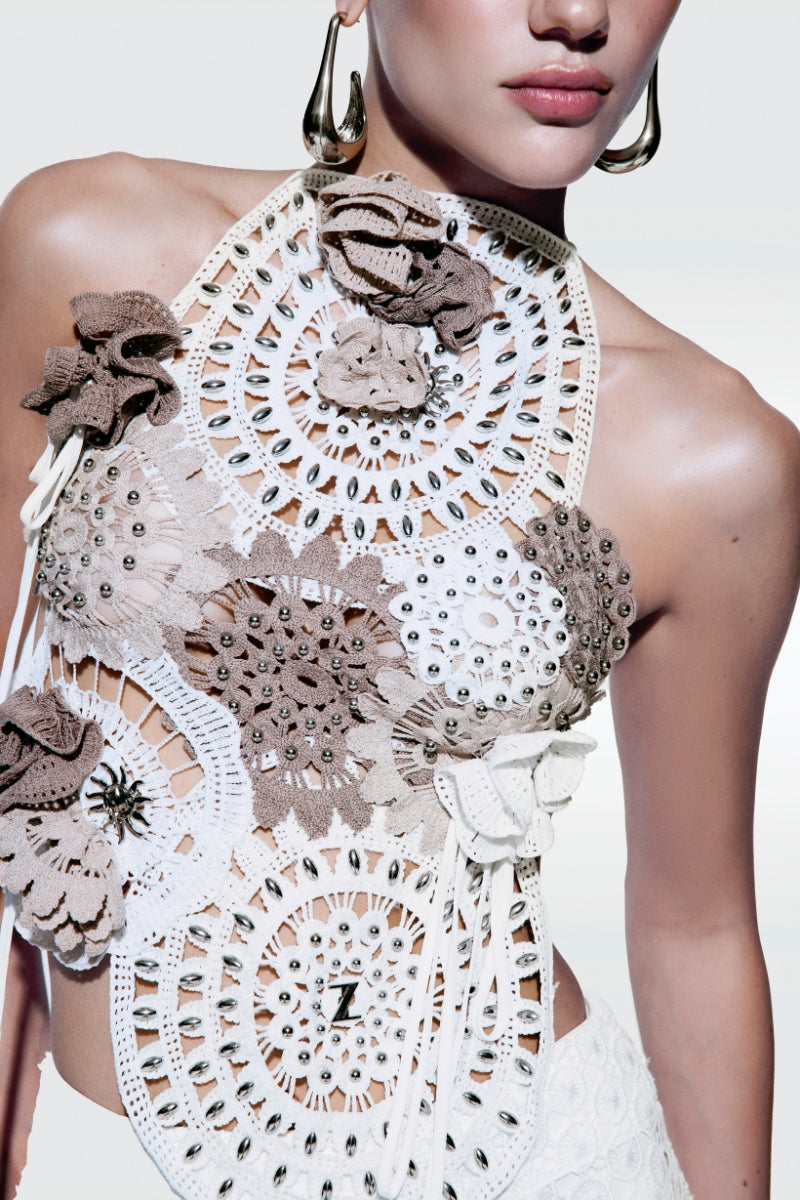 Off-white asymmetrical broderie top by Zeynep Tosun, featuring intricate embroidery and stylish design details.
