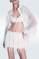 Off-white broderie mini skirt by Zeynep Tosun, featuring intricate embroidery and a stylish, feminine design.