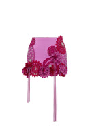 Pink floral mini skirt by Zeynep Tosun featuring a fitted waist and intricate floral patterns, shown from the front.