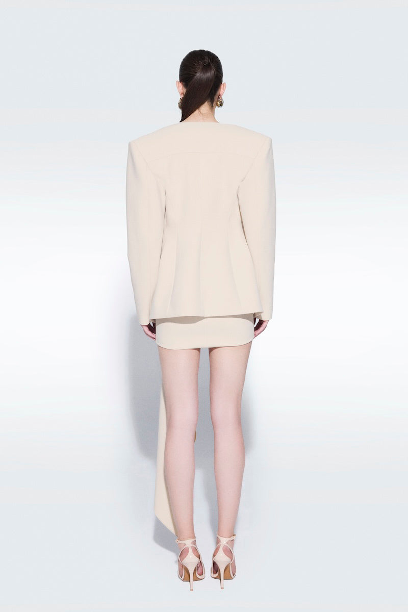 Beige draped mini skirt by Zeynep Tosun featuring flowing fabric and stylish design, shown on a model.