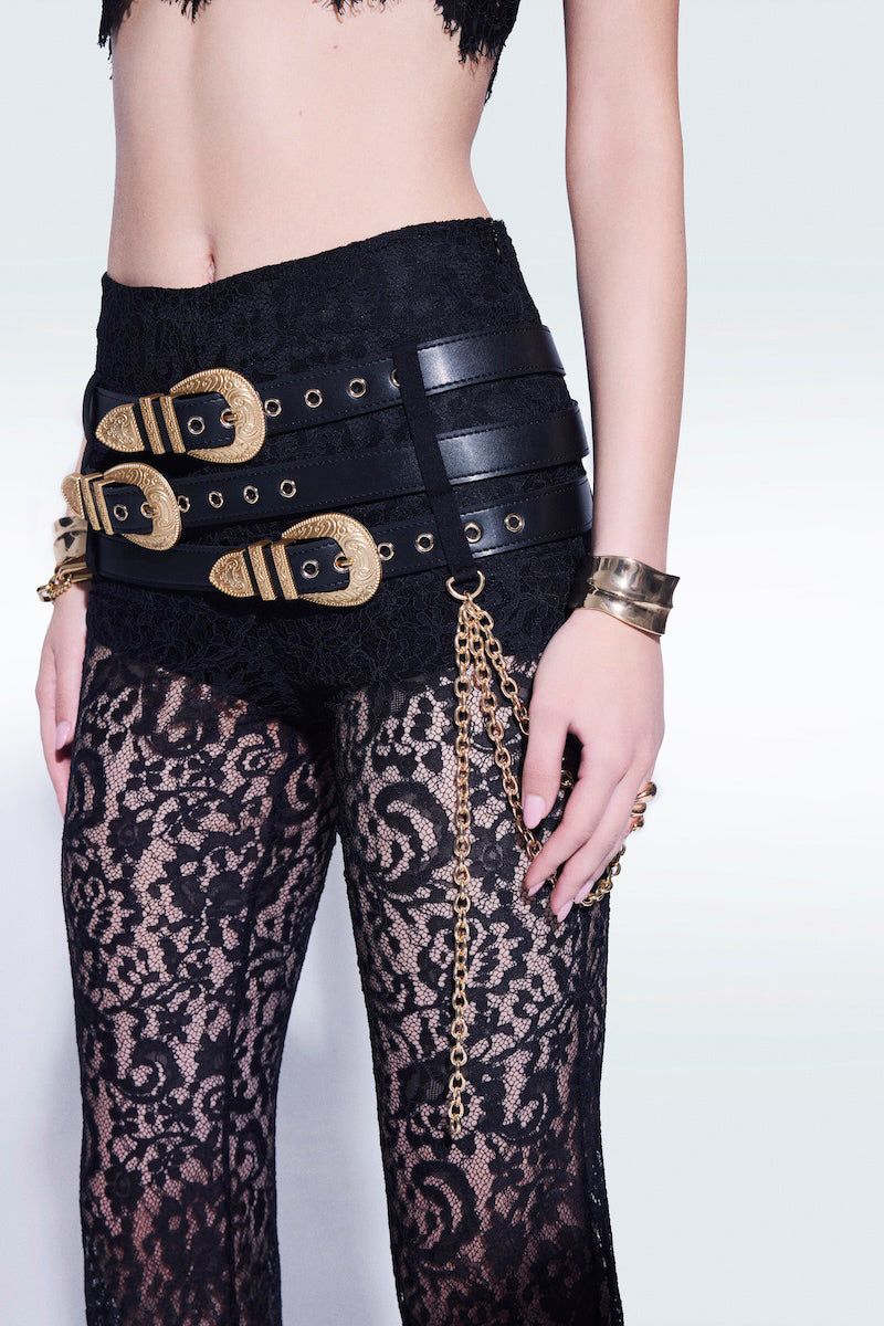 Black lace pants with belts by Zeynep Tosun, featuring intricate lace details and stylish belt accents.