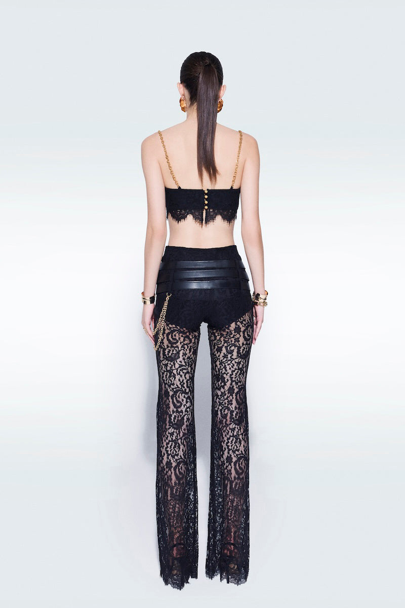 Black lace pants with belts by Zeynep Tosun, featuring intricate lace fabric and stylish belt accents.