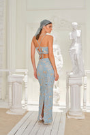 Nana Gotti Zeyna Maxi Dress in flowing fabric with a fitted waist and elegant neckline, perfect for summer occasions.