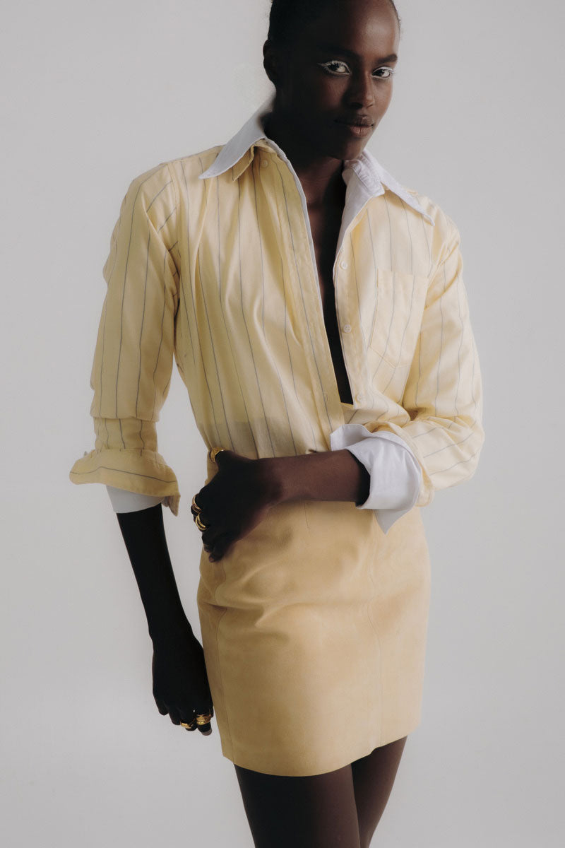 ZUT ZIA yellow mini skirt with a fitted waist and stylish design, shown on a model in a casual setting.