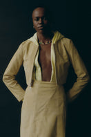 ZUT ZIA yellow top with short sleeves and round neckline, made from soft fabric, displayed on a hanger.
