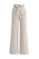 Light beige Zima pants by ANA + MARIA displayed on a ghostly figure, showcasing relaxed fit and soft fabric in natural setting.
