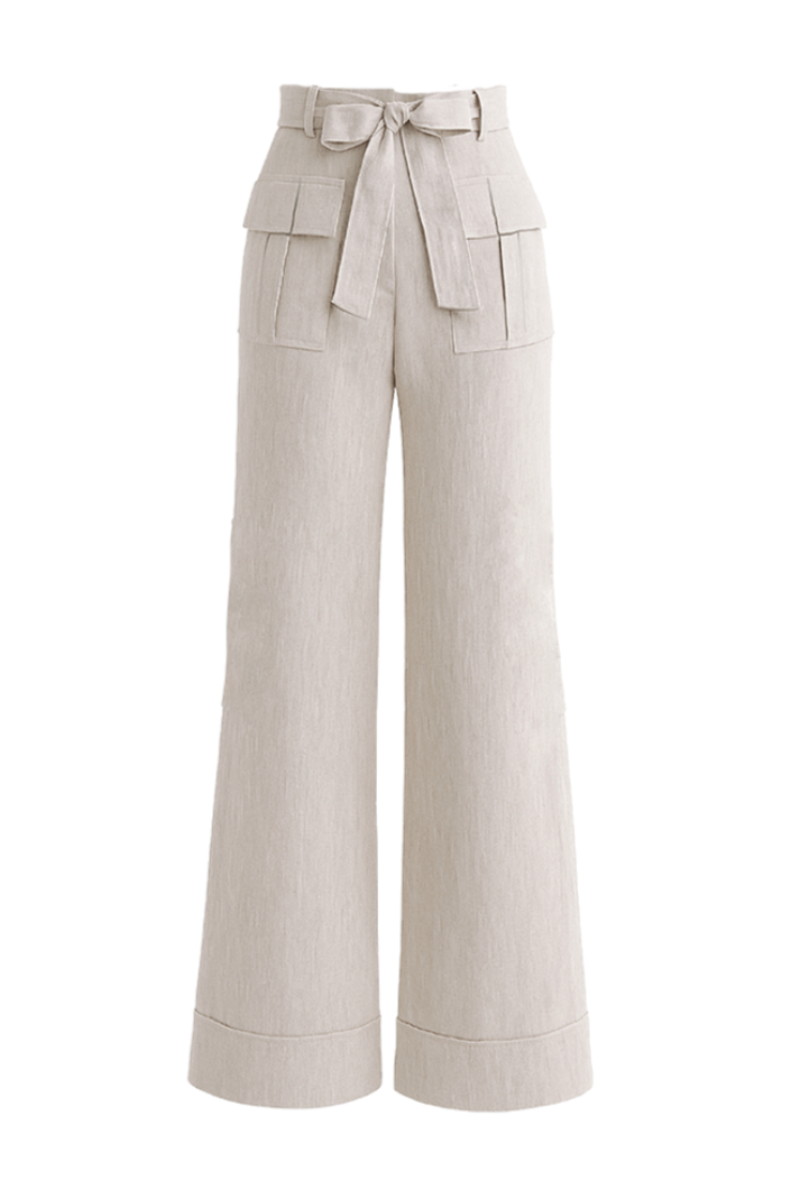 Light beige Zima pants by ANA + MARIA displayed on a ghostly figure, showcasing relaxed fit and soft fabric in natural setting.