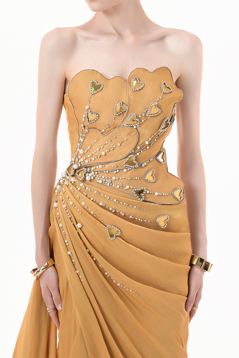 Elegant chartreuse gold gown with heart embellishments and draped design by Happy Clothing, shown on a mannequin.