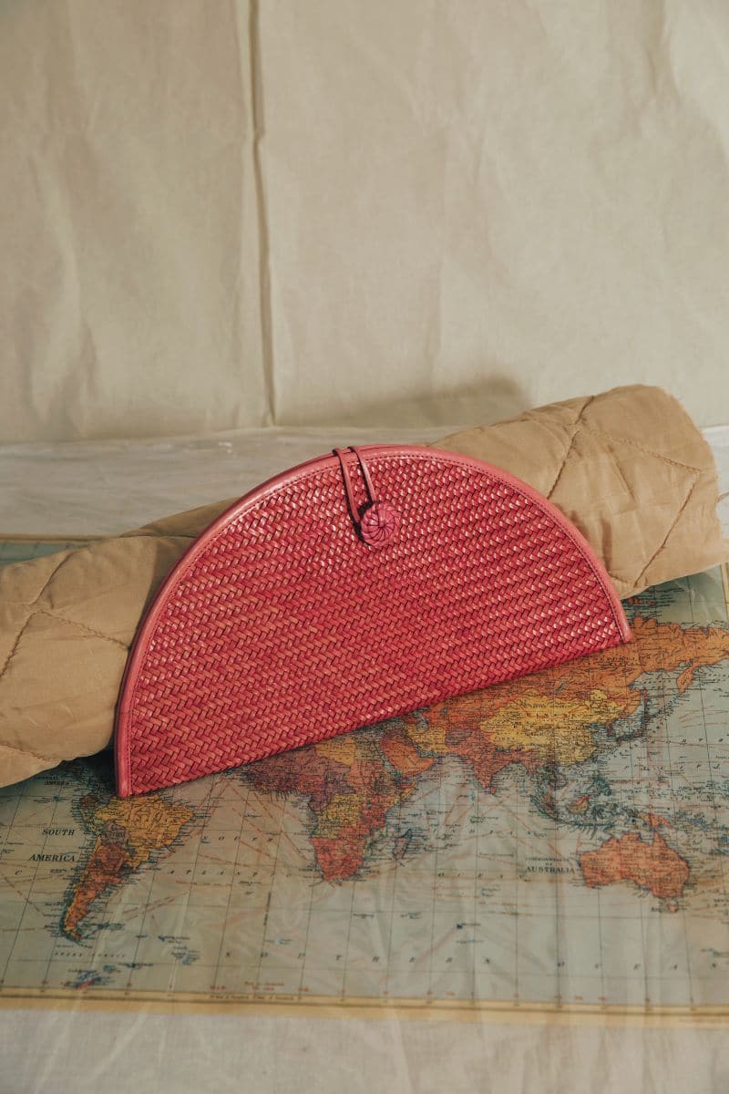 Pink leather clutch by Adriana Castro featuring a sleek, elegant design with subtle stitching and a minimalist style.