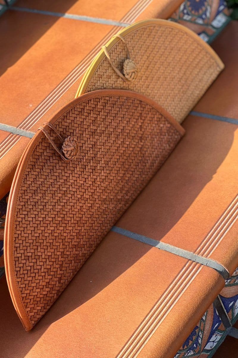 Tan leather clutch by Adriana Castro featuring sleek design and minimal detailing, perfect for elegant occasions.