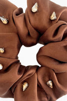 A set of Aethera Amara rhinestone embellished silk scrunchies in crimson, pistachio, and brown for hair accessories.