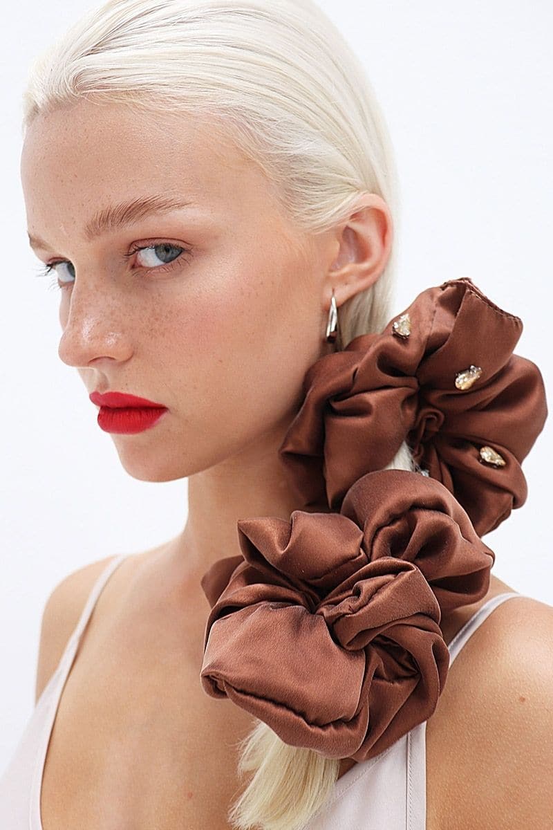 A set of Aethera Amara rhinestone embellished silk hair scrunchies in crimson, pistachio, and brown with sparkling rhinestone details.