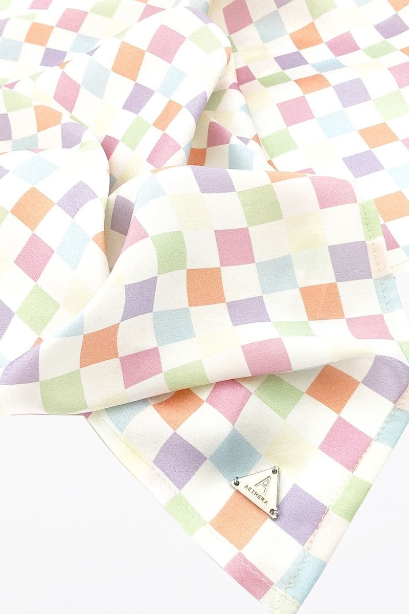 Aethera checked Charlotte silk square scarf and Isla silk front tie pareo set in multicolor, styled as hair accessories and beach wear.