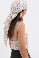 Aethera checked Charlotte silk square scarf and Isla silk front tie pareo set in multicolor, styled as elegant hair accessories.