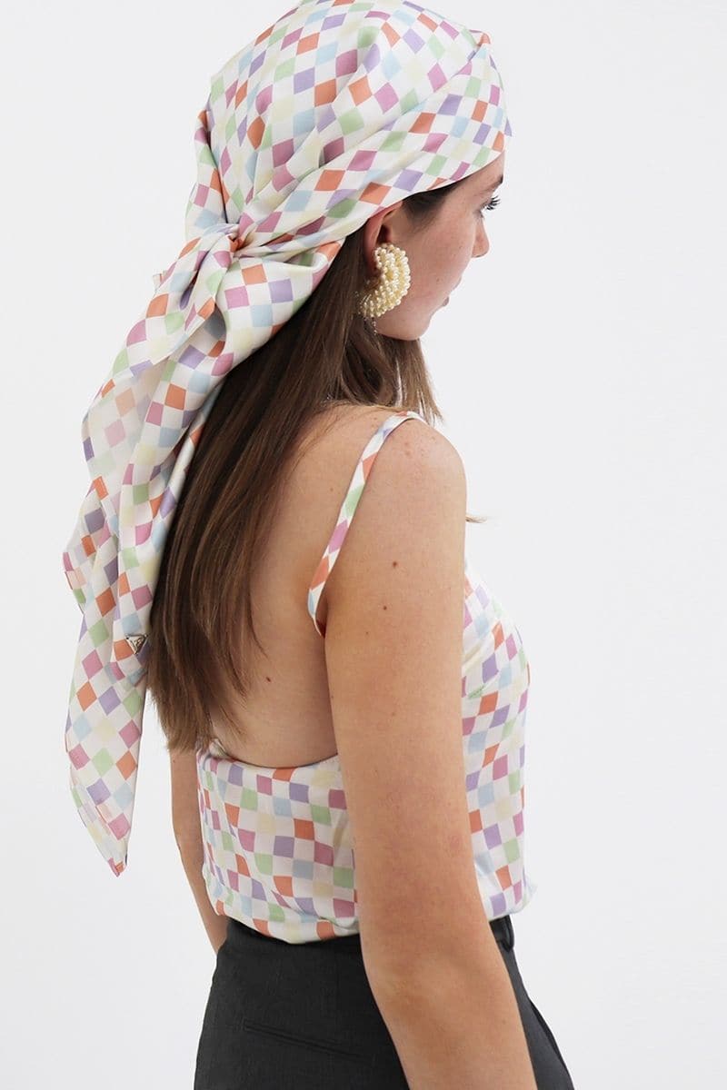 Aethera checked Charlotte silk square scarf and Isla silk front tie pareo set in multicolor, styled as elegant hair accessories.