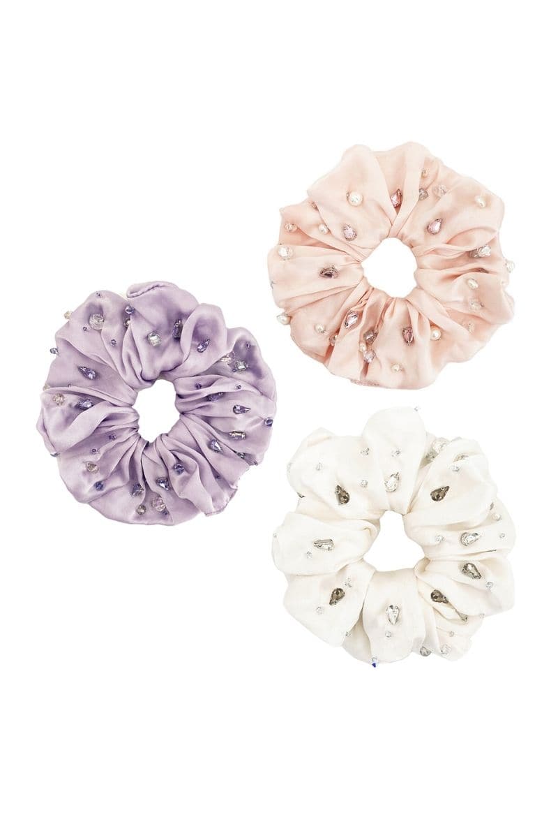 A set of Aethera Harlow embellished oversized silk scrunchies in mauve rose with pearl accents, styled as hair accessories.