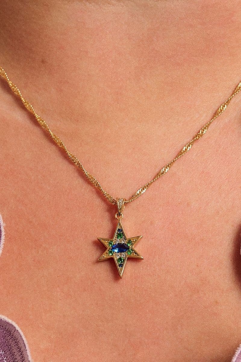 Gold Nova Necklace by Amelia Scott featuring emerald green and sapphire blue gemstones on a delicate gold chain.