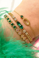 Gold Sofia bracelet by Amelia Scott featuring emerald green accents, displayed on a neutral background.