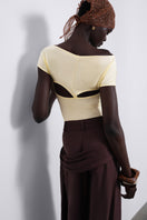 SÉLONE Aureon cut-out bodysuit in butter yellow, featuring stylish open shoulder design and fitted silhouette.