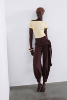 SÉLONE AUREON cut-out bodysuit in butter yellow, featuring a stylish design with cut-out details, worn as a fashionable top.