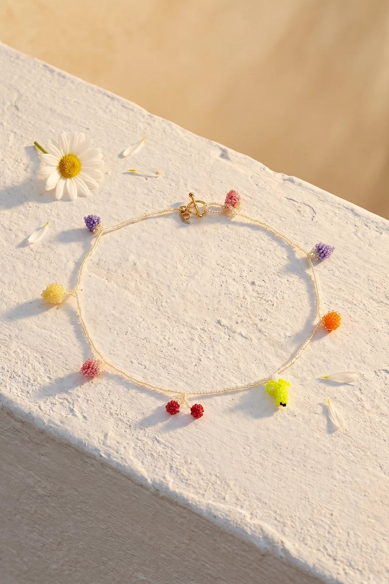 Pura Utz Pale Fruit Salad Necklace featuring colorful fruit-shaped charms on a delicate chain.