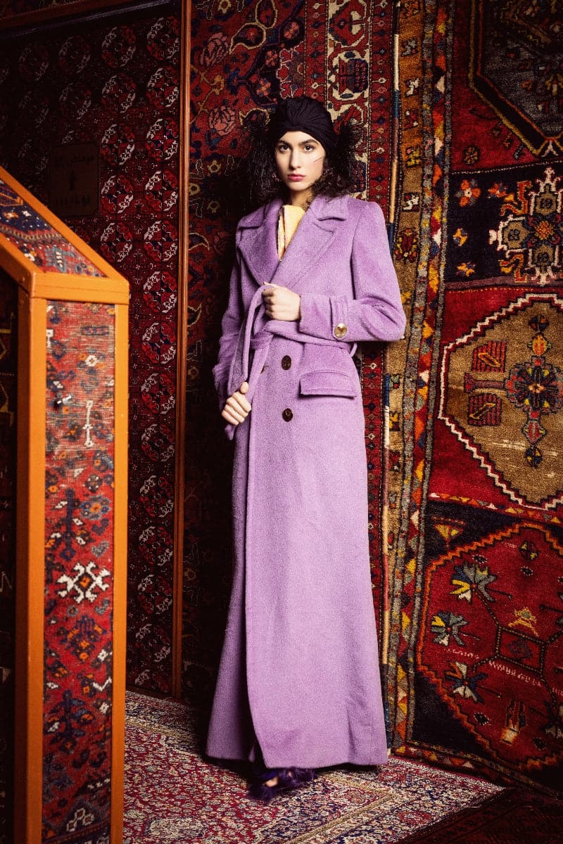 Nana Gotti jade double-breasted cashmere-wool coat hanging on a rack, showcasing its tailored design and elegant fabric.