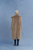 Brown oversized shearling coat by JINSUN shown from the back, featuring plush shearling material and relaxed fit style.