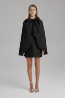 Black IRIS JET Cape jacket by BAÉ featuring a sleek, modern design and flowing fabric, styled for a fashionable look.