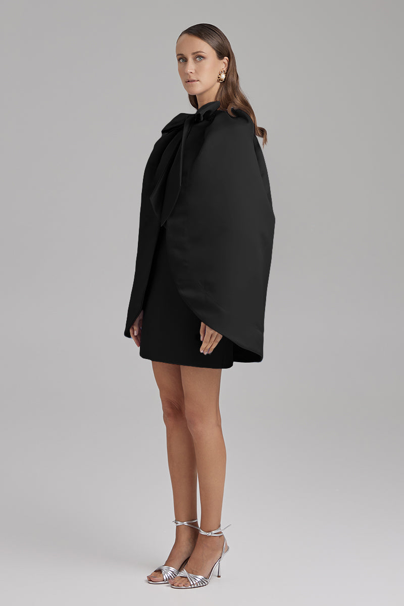 Black IRIS JET Cape jacket by BAÉ displayed on a model, showcasing its stylish design and sleek silhouette.
