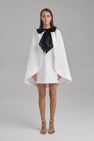White IRIS STAR cape jacket by BAÉ, showcasing a stylish, elegant outerwear piece with intricate details and a flowing design.