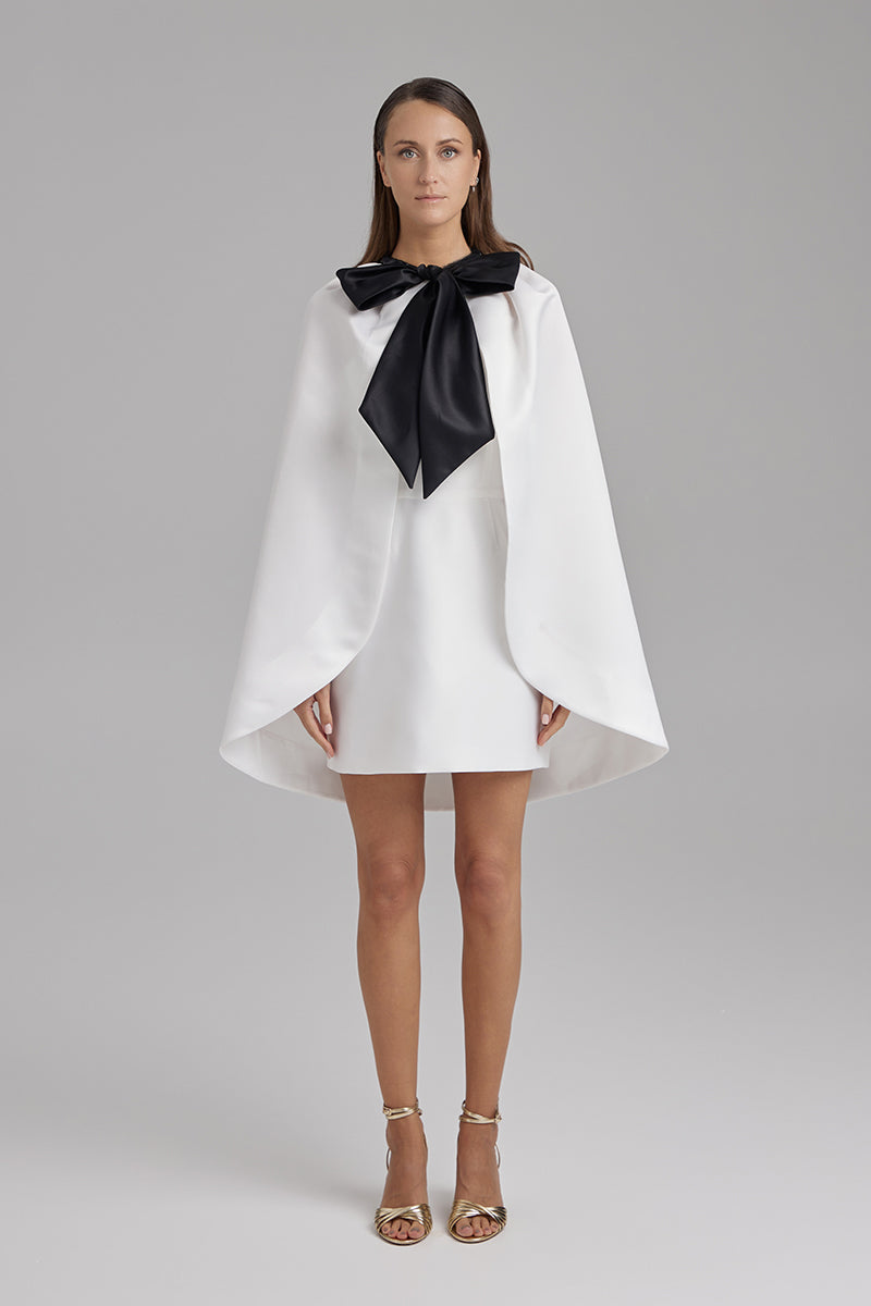 White IRIS STAR cape jacket by BAÉ, showcasing a stylish, elegant outerwear piece with intricate details and a flowing design.