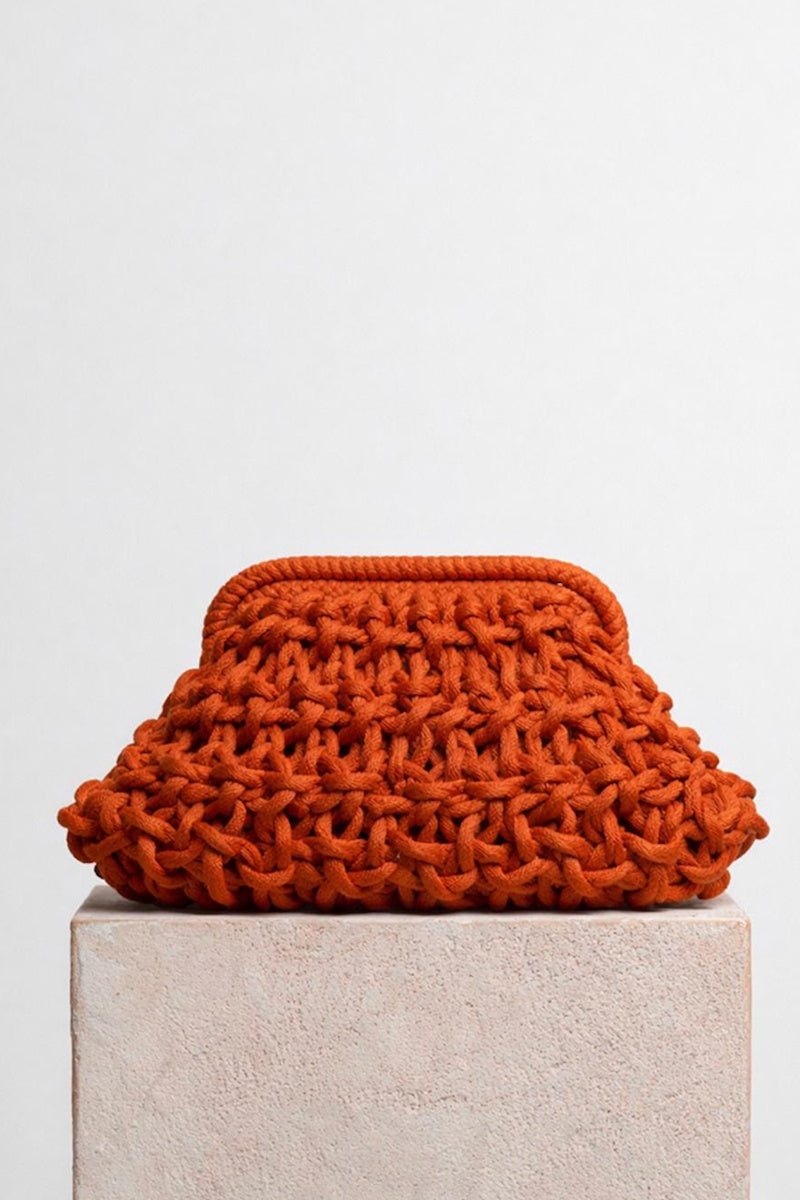 Rust-colored small rope clutch bag from Folklore The Label with woven texture and compact design.