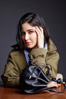 Black pebble leather mini crossbody bag from behno New York featuring a top handle and compact design.