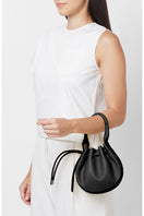 Black pebble leather mini crossbody bag with top handle from behno New York, featuring a sleek, compact design.